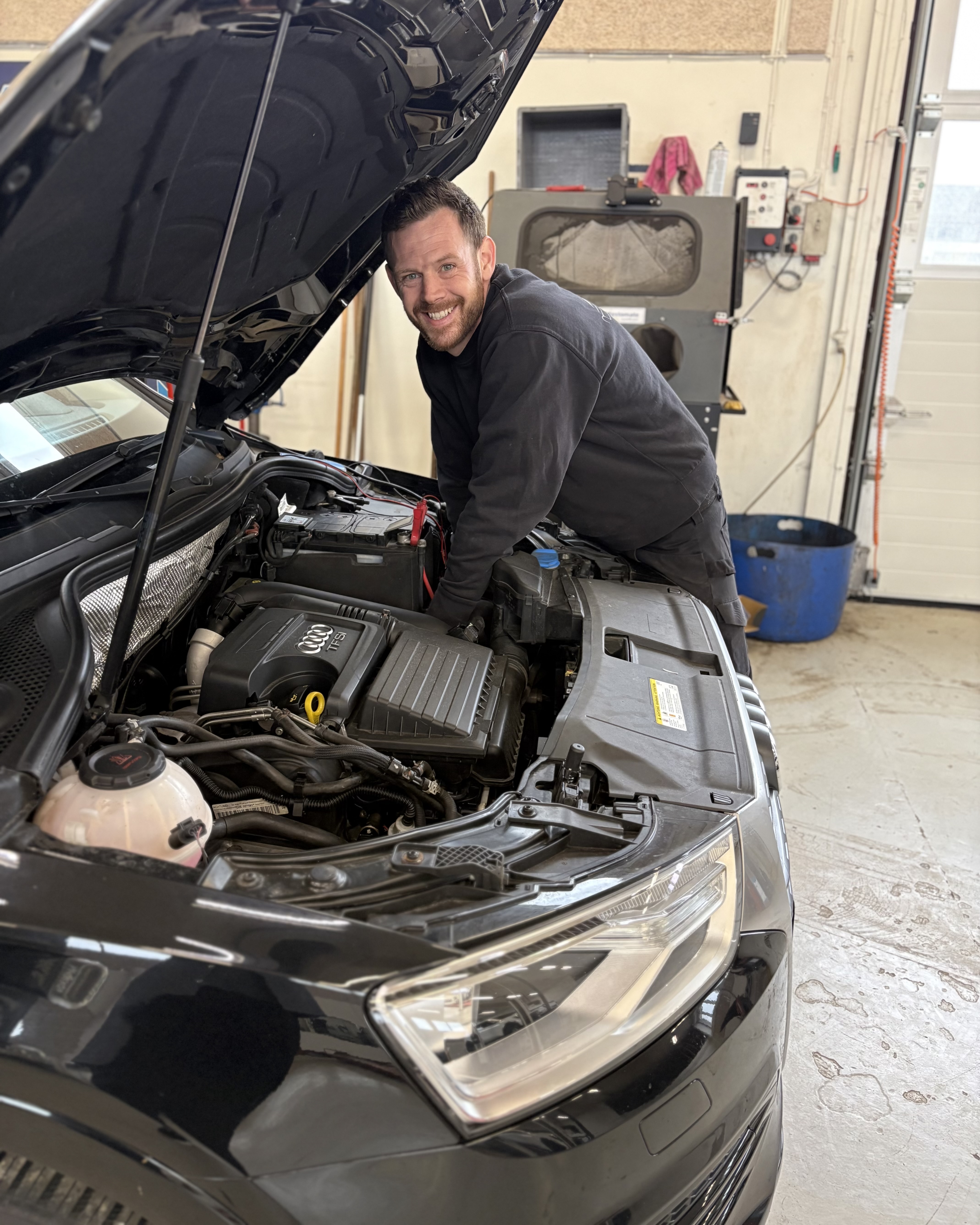 Nicklas Lind Salvig arbejder under motorhjelmen på en bil.
